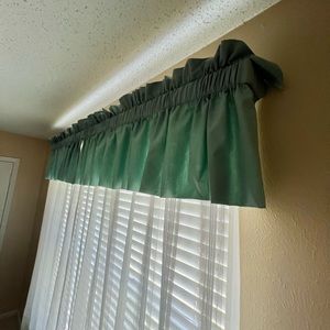 Teal green valance for double windows with white sheer curtains.